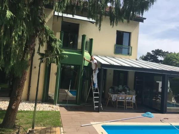 Abords d’une piscine : véranda, auvent et boiseries en cours de traitement