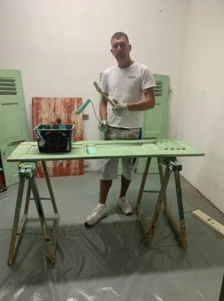 Volet posé sur tréteaux dans l’atelier, protections au sol