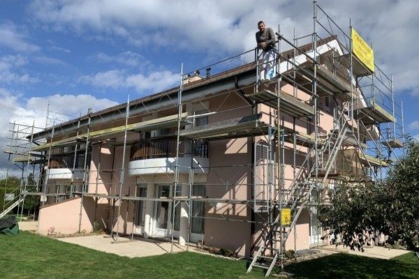 Maison à balcons échafaudée pour la remise en peinture de sa façade
