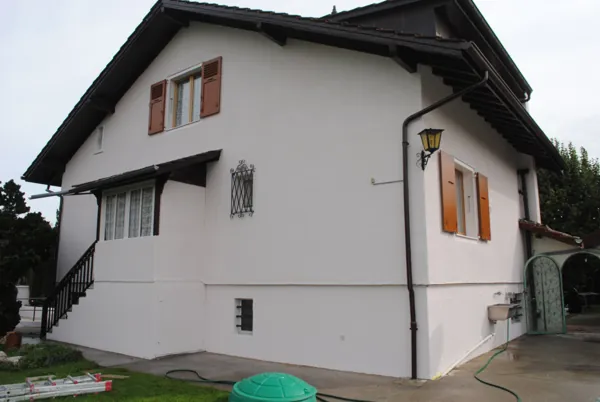 Façade crépie d’une maison, repeinte en teinte claire
