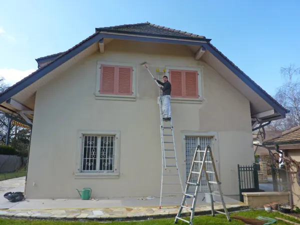 Villa au crépi repeint sous un toit de tuiles, jardin devant