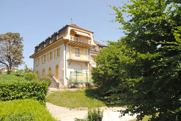 Villa ancienne aux volets clairs, vue depuis le jardin