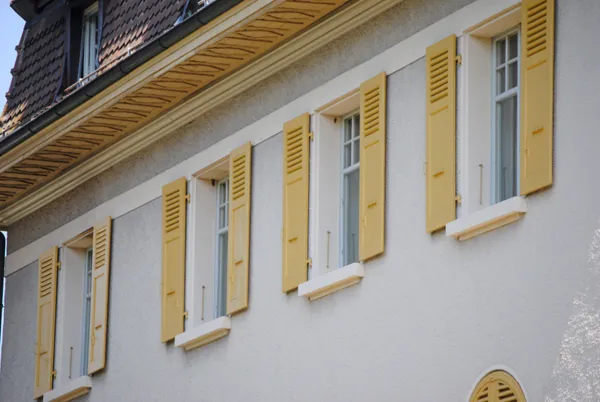 Volets jaunes sur une maison blanche