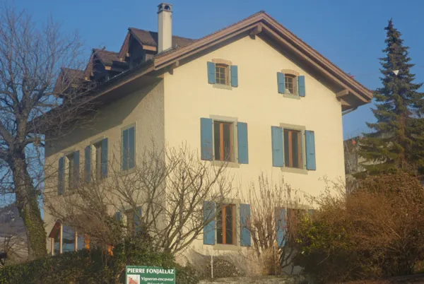 Ferme jaune aux volets verts restaurés